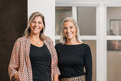 Ines und Stefanie Karl vor einer weißen Kunststoff-Fenstertür