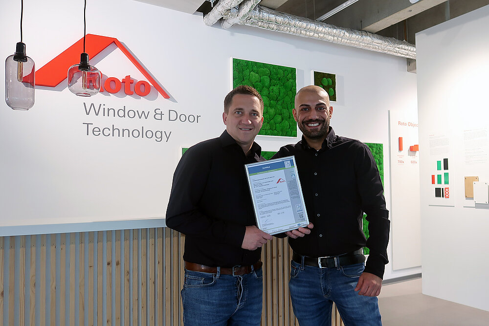Two men are holding the certificate in their hands