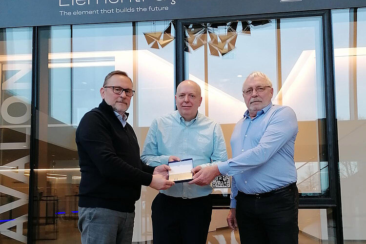 Reynaers Category Manager Eddy De Meier (left) hands the plaque for the Reynaers Supplier Award 2024 over to Jean-Paul Batenburg, Head of Sales Deventer West (centre of image), and Johan Claes, Key Account Manager Deventer West / System Suppliers.