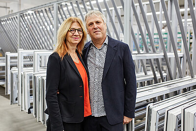 FTR-Inhaber Thomas Rösler mit seiner Frau Ina vor Fensterrahmen im Hintergrund