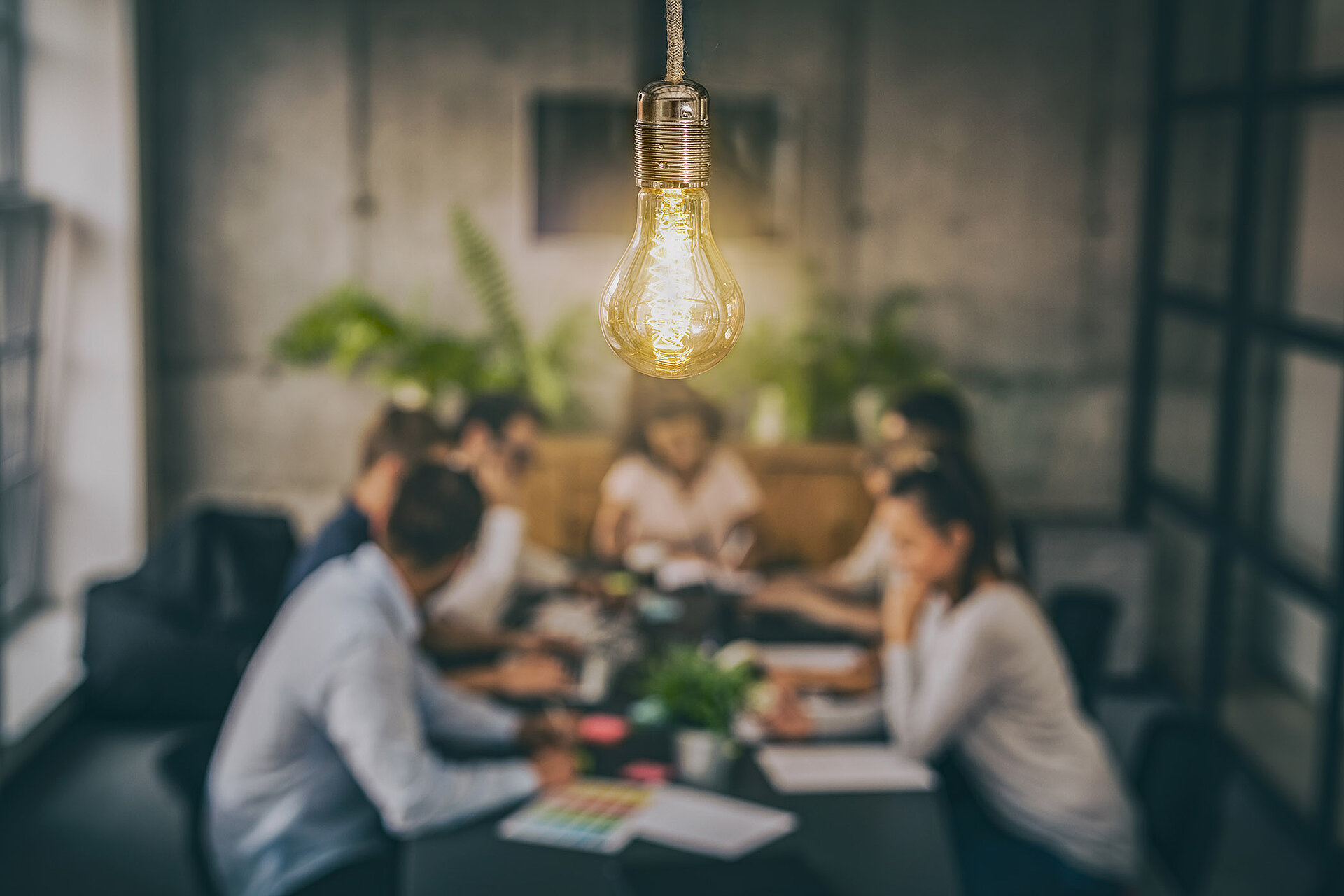 People sitting around a table with a light bulb